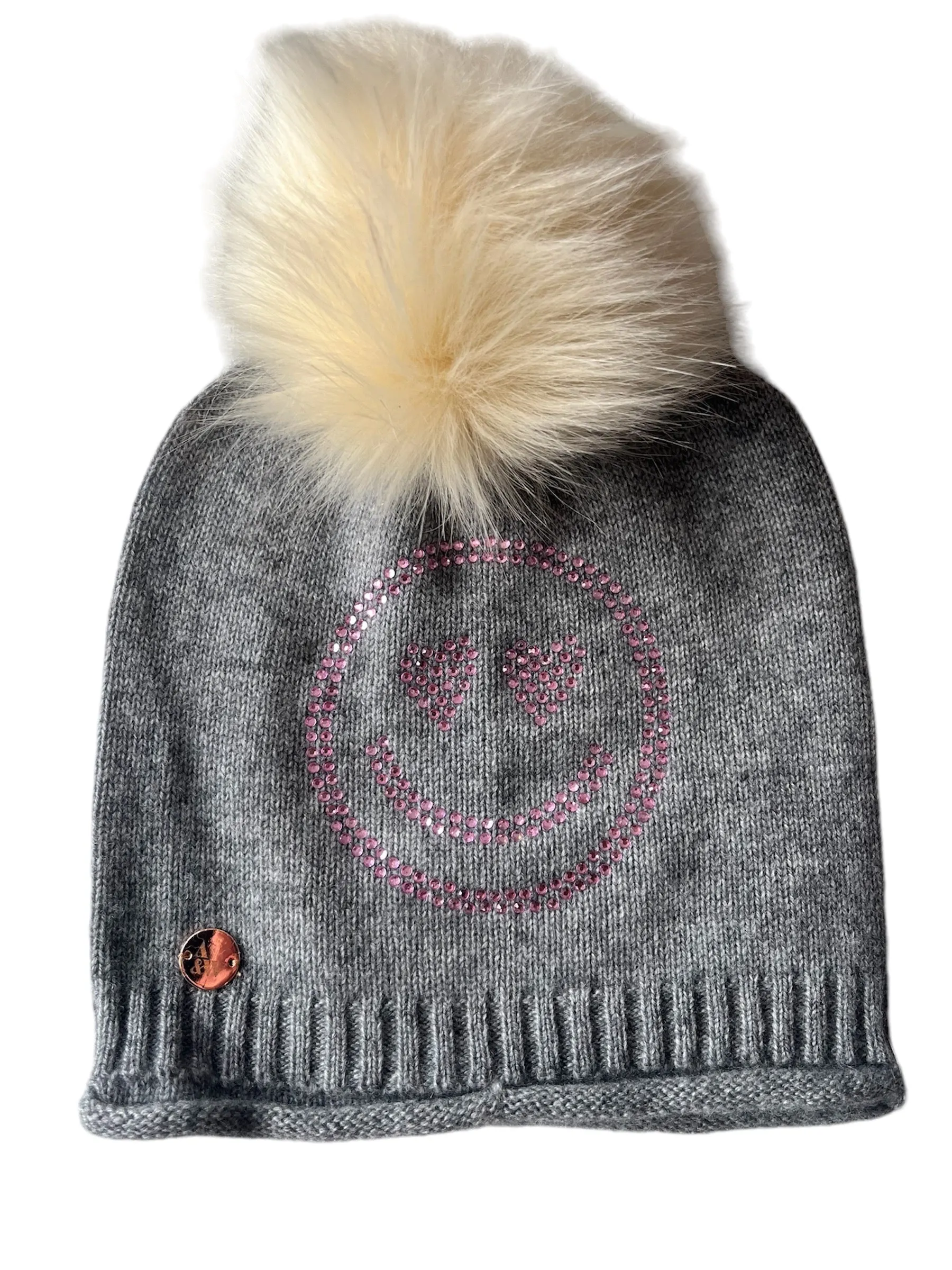 Grey cashmere plain knit beanie with a pink smiley embellishment & faux fur pom