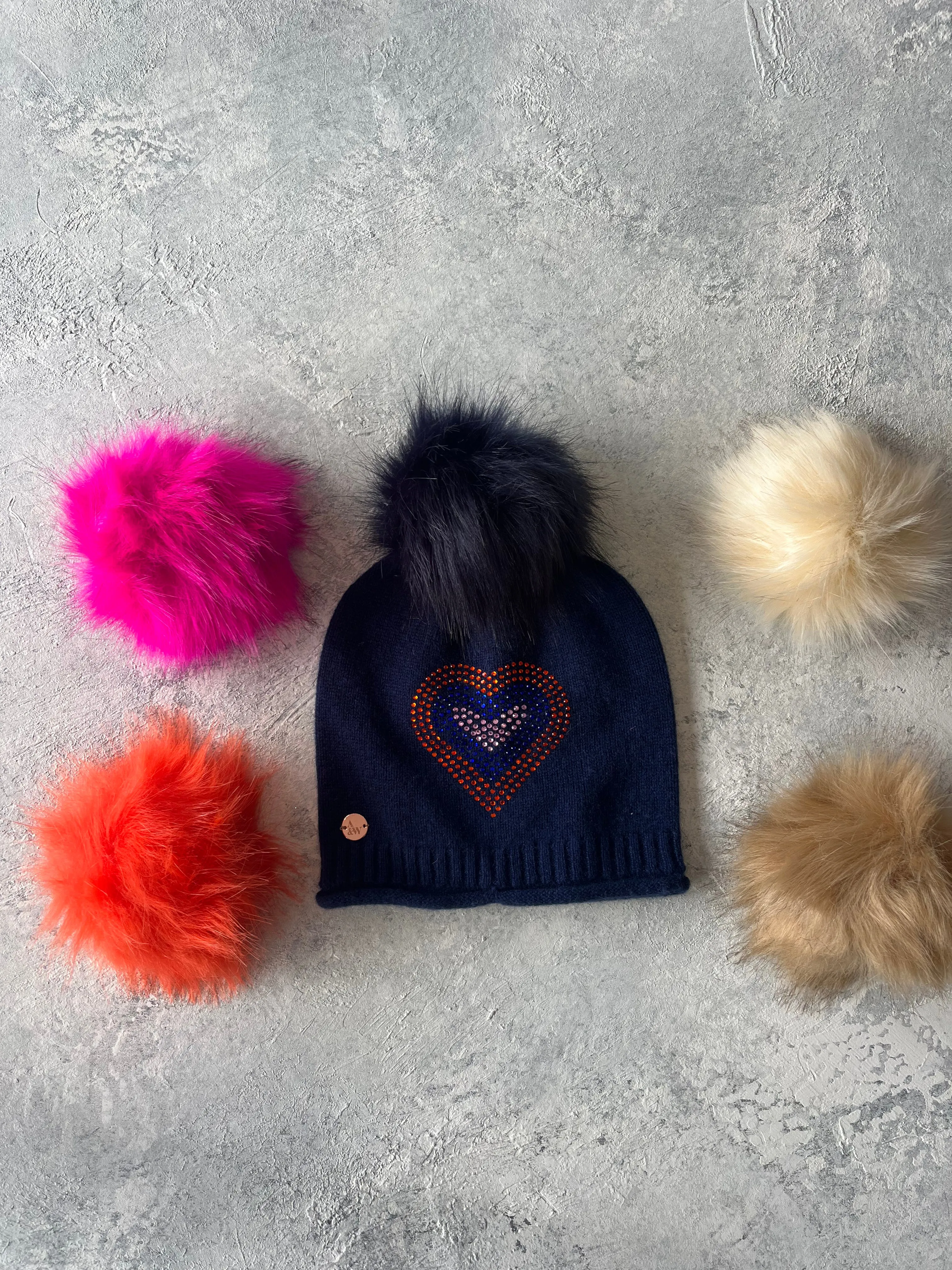 Navy cashmere plain knit beanie with heart embellishment & faux fur pom